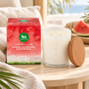 BX Earth Riverina Watermelon and Buttercream candle with red packaging and timber lid on a pale timber table.