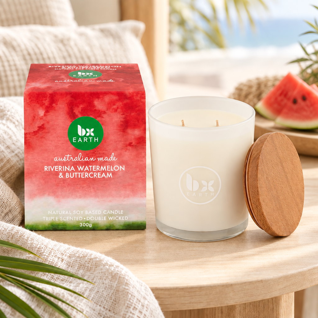BX Earth Riverina Watermelon and Buttercream candle with red packaging and timber lid on a pale timber table.
